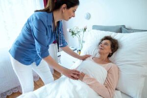 A caregiver helping an elderly resident with a daily activity in a comfortable assisted living setting.