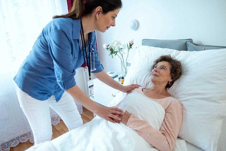 A caregiver helping an elderly resident with a daily activity in a comfortable assisted living setting.