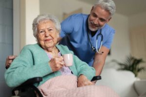 A group of seniors laughing together while participating in a light indoor exercise class.