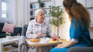 Older adult arranging familiar belongings in a new assisted living room with family support.